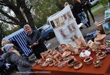 Художник Анатолій Риженко автографить на книзі "Це серйозно". Ніжин. Покровський ярмарок